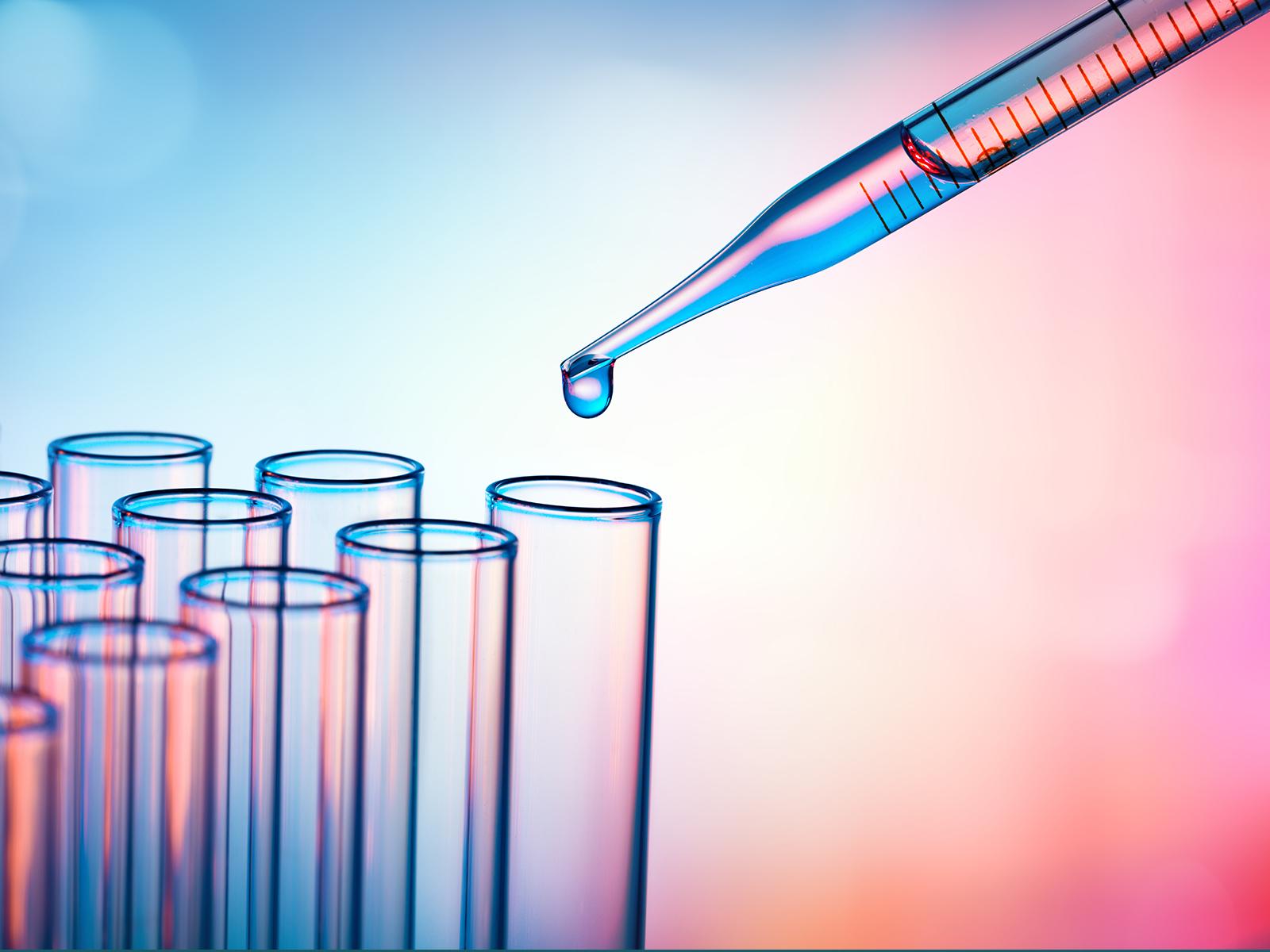 A pipette dropping liquid into test tubes